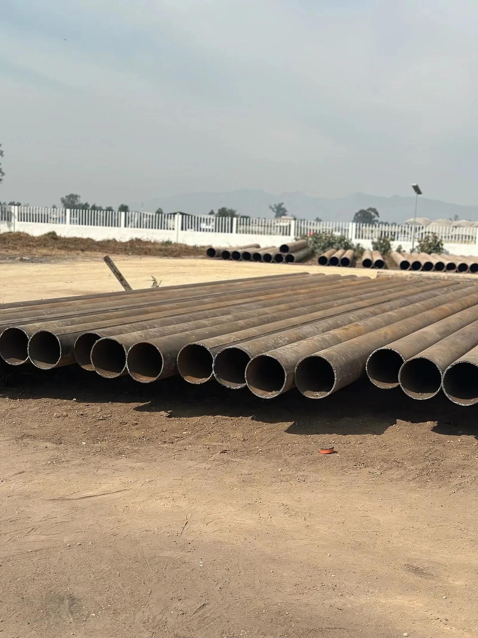 Patio de acopio con filas de tubería de gran diámetro